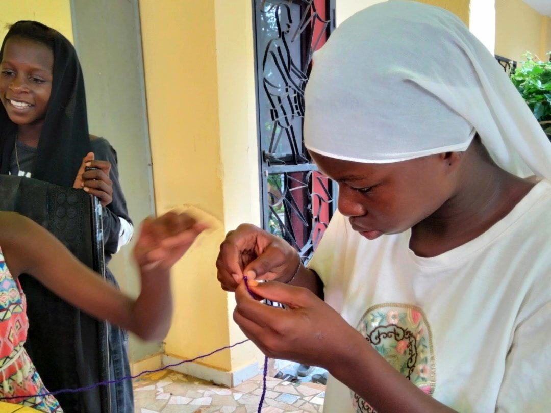 Due ragazze del centro lavorano con ago e filo durante un laboratorio in Senegal