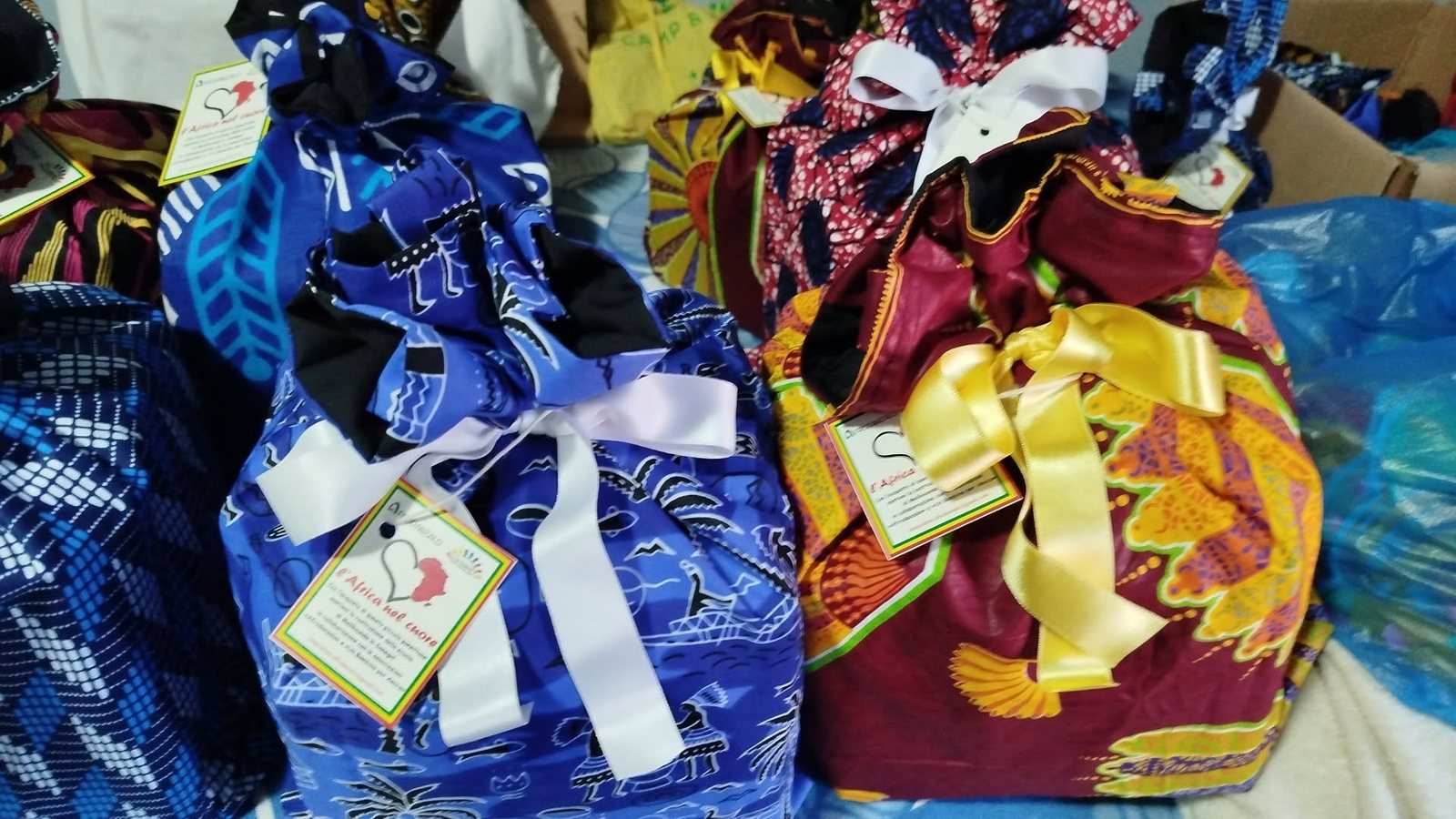 Solidarni panetoni upakovani u torbe od afričke tkanine sa šarenim mašnama i etiketama