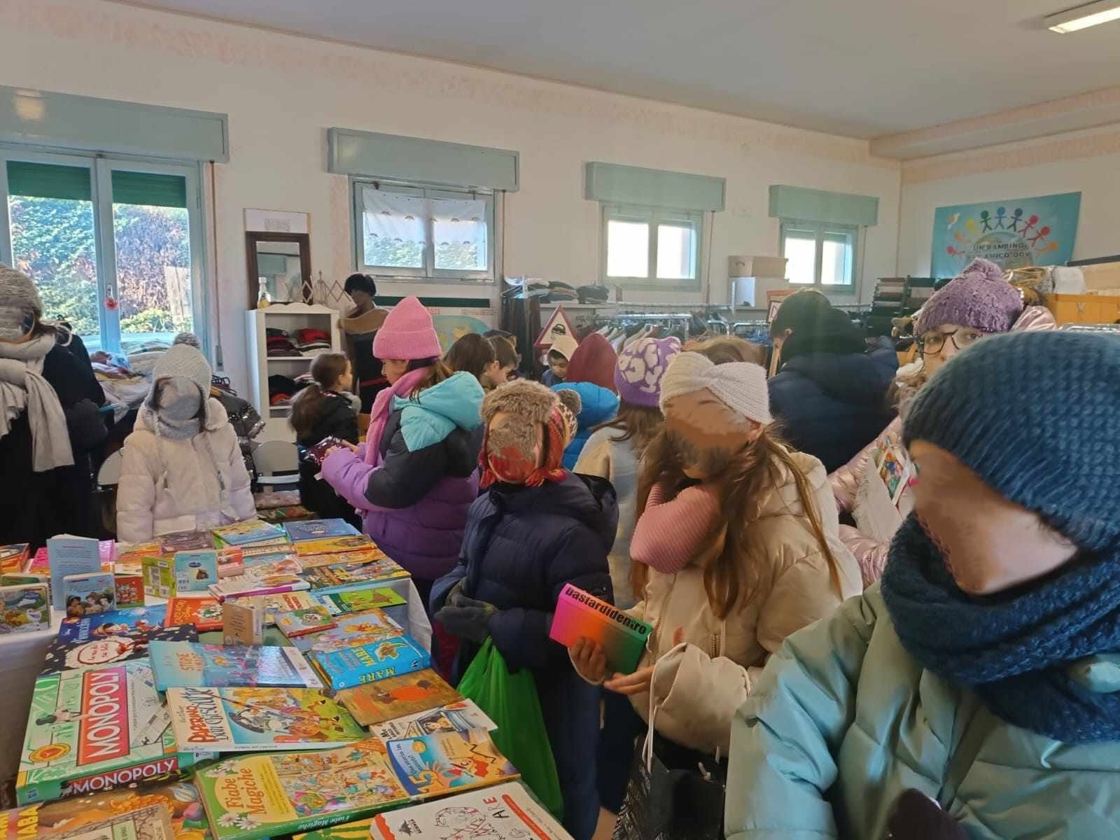Una classe della scuola primaria visita libri e giochi esposti al Bazar Ubuntu