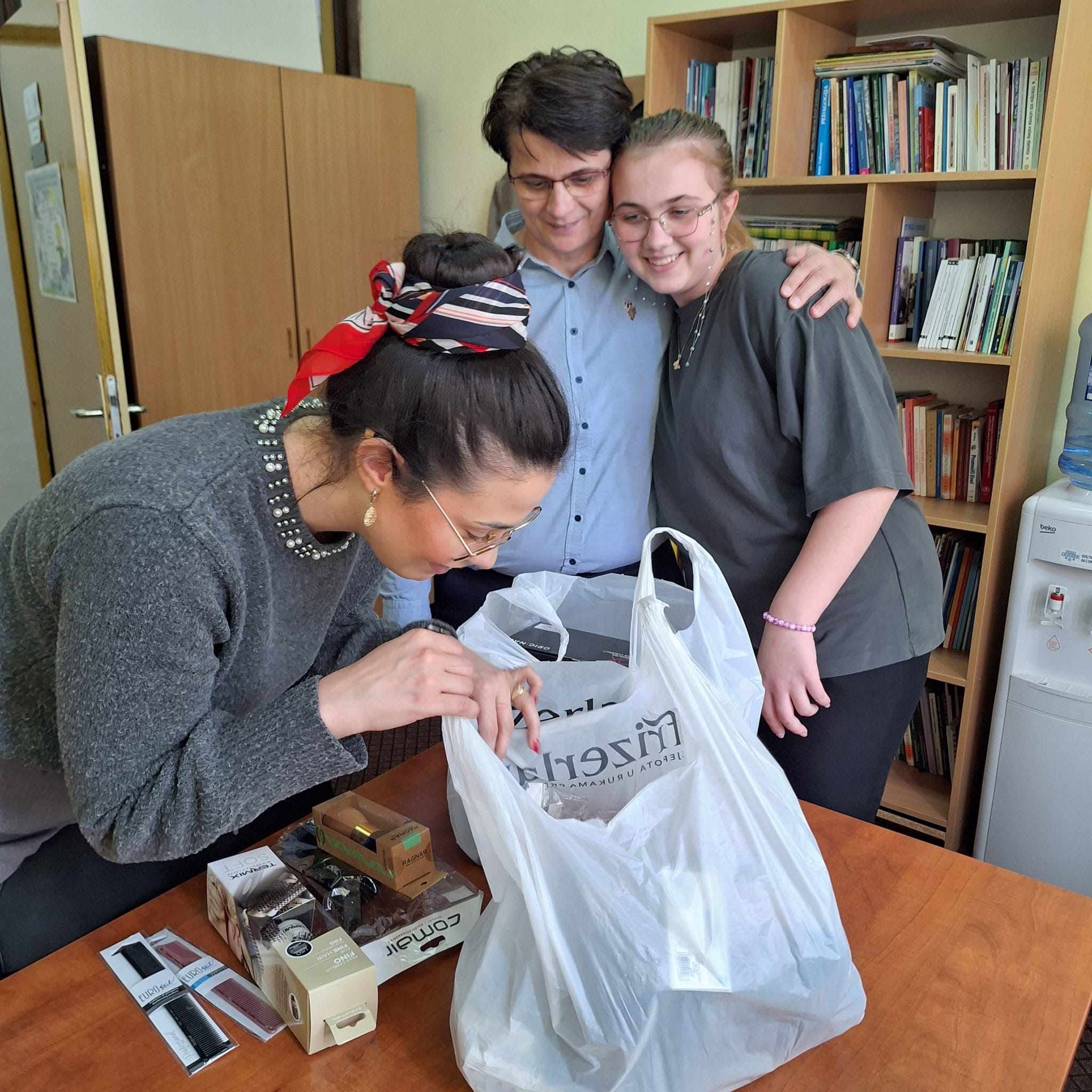 Dobitnica stipendije sa dve odrasle osobe tokom predaje kupljene opreme