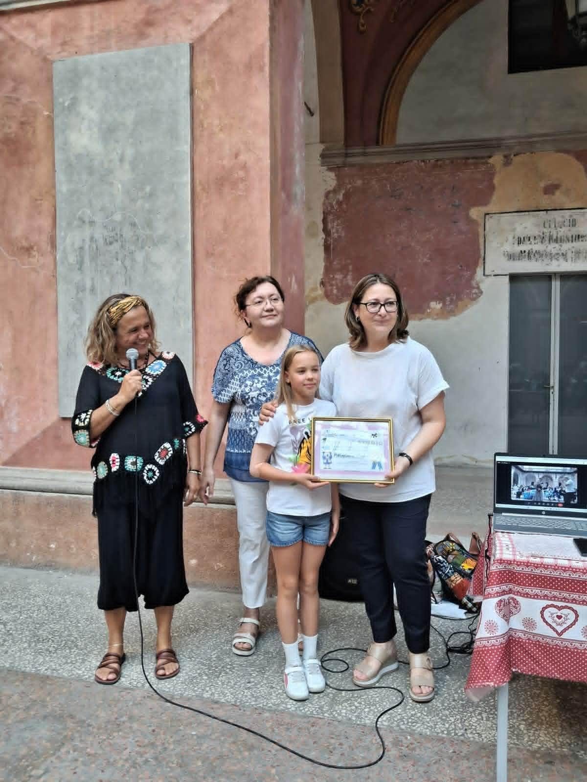Jedna od nagrađenih prima stipendiju zajedno sa dve volonterke udruženja