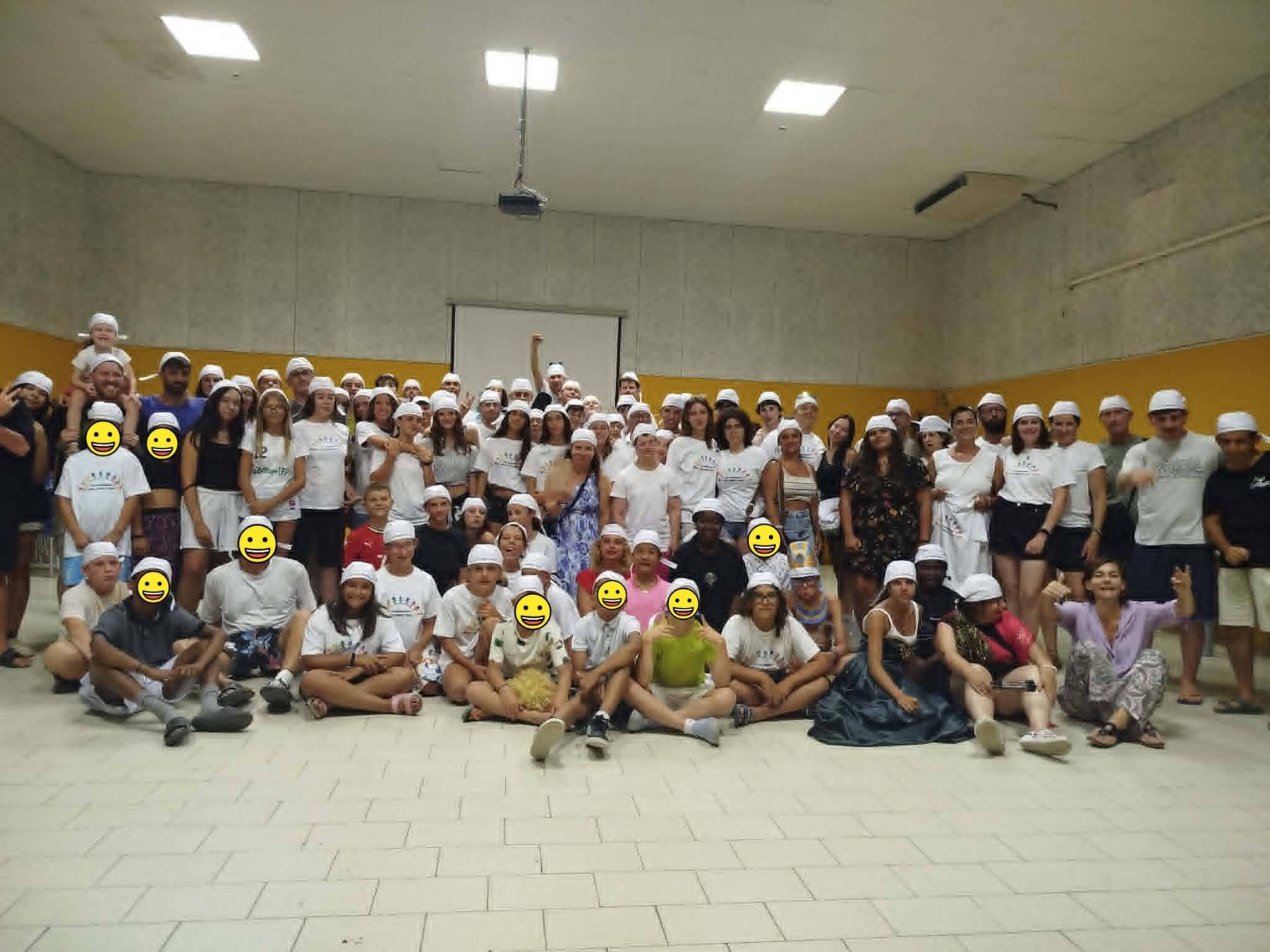 Il gruppo del campo estivo con le magliette e i cappellini bianchi dell'associazione