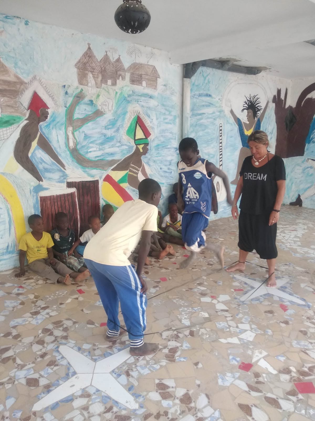 Deca se igraju sa volonterkom tokom putovanja u Senegal u januaru 2025.