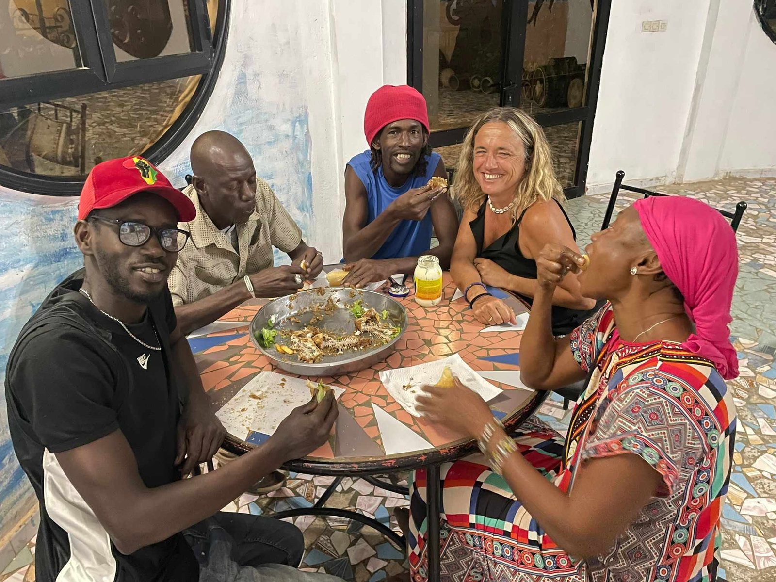 Il gruppo del viaggio mangia insieme attorno a un unico grande piatto condiviso
