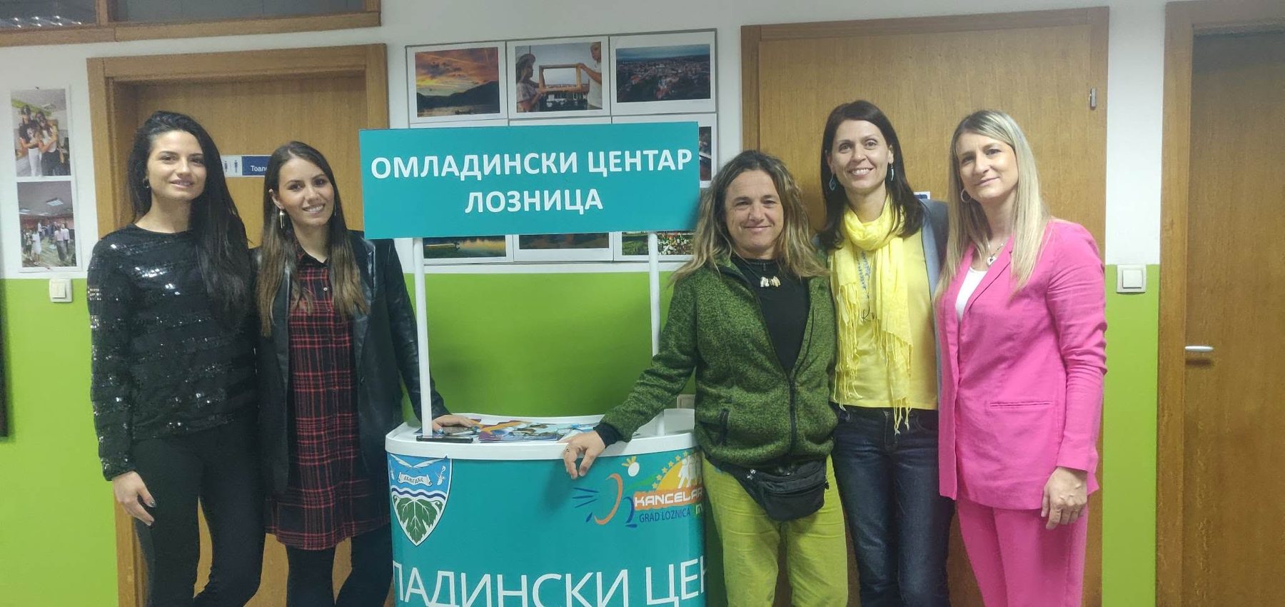 Cinque partecipanti al viaggio accanto all'insegna del Centro giovani di Loznica